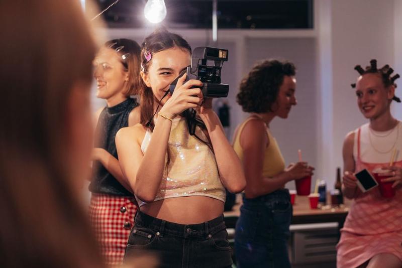 Friends snapping instant photos at a house party